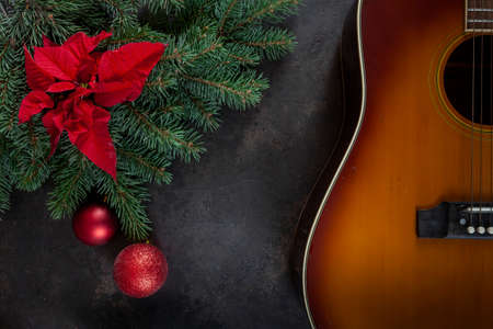 Acoustic guitar and Christmas tree branches with poinsettia. Top view, close upの写真素材