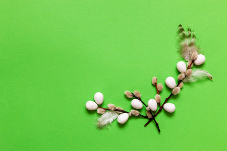 Top view of Easter eggs, pussy willows, small bunny figurines and feathers. Easter concept on green background. Greeting card, space for textの写真素材