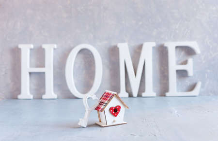 Close up of house model with key. Concept of building houses, residential settlement, choosing your own house, mortgage, buying and selling residential area, rental, insurance, and investment real estate.の写真素材