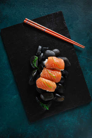 Japanese sushi served on black stones. Top view, close up on dark backgroundの写真素材