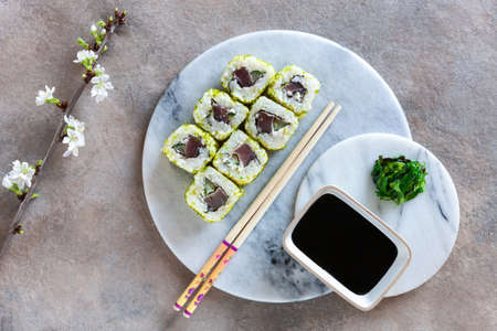 Japanese sushi served with spring cherry tree blossoming branches. Top view, close up on light background.の写真素材