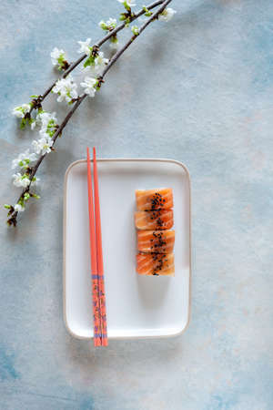 Japanese sushi served with spring cherry tree blossoming branches. Top view, close up on light background.の写真素材