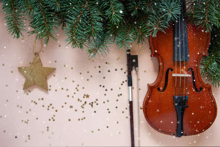 Old violin and fiddlestick, fir-tree branches with Christmas decor. Christmas, New Year's concept....
