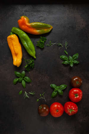 Close-up photo of fresh farm organic vegetables and greenery. Top view on dark concrete backgroundの写真素材