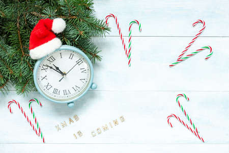 Christmas and New Year composition with clock in Santa hat showing the eve of the holiday and Santa...