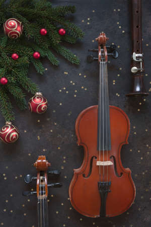 Two Old violins and flute with fir-tree branches with Christmas decor. Christmas and New Year's concept. Top view, close-upの写真素材