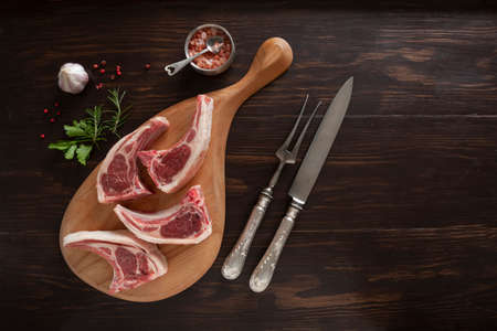 Fresh raw lamb on ribs on dark wooden background