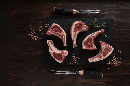 Fresh raw lamb on ribs on dark wooden backgroundの写真素材