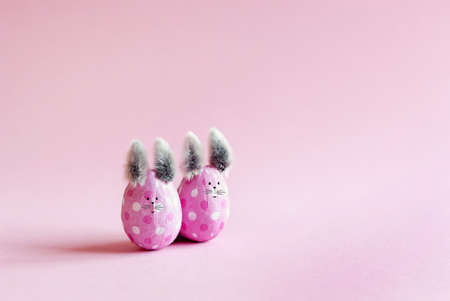 Pink Easter eggs in the form of bunnies on a pink backgroundの写真素材