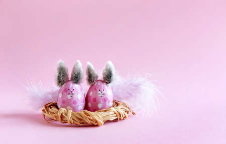Pink Easter eggs in the form of bunnies on a pink backgroundの写真素材