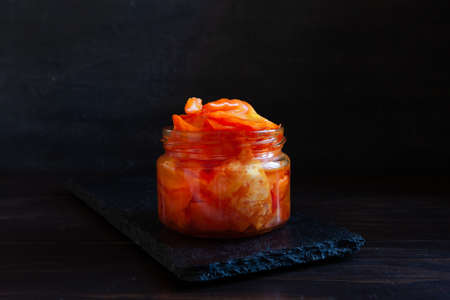 Close-up of orange-pink colored organic Cabbage in glass jars, fermented with seasonings and pomegranate juice.の写真素材