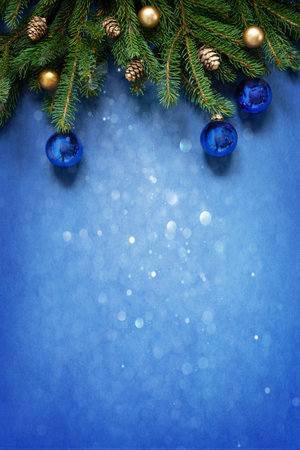 Christmas and New Year festive composition with fir tree branches, golden Christmas balls and cones on the deep blue backgroundの写真素材