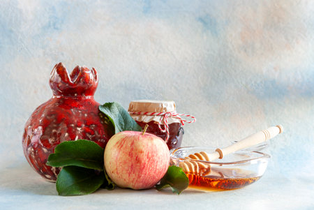 Apple, pomegranate, honey. Concept for Rosh Hashanah the Jewish New Year. Close up on light blue background.の写真素材