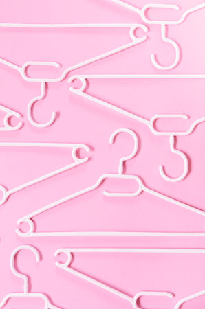 White plastic hangers on a pink background. Concept for sale, shop, second hand, online trade, brand...