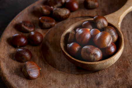 Fresh sweet edible chestnuts in wooden bowl, closeupの写真素材
