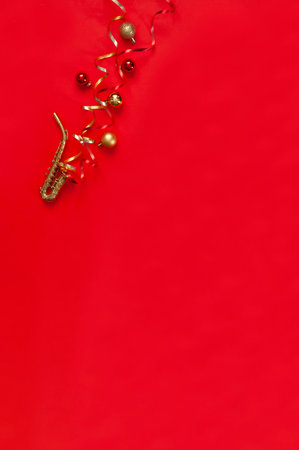 Festive red Christmas and New Year background with Miniature golden saxophone copy and Christmas decor. Top view, copy space, flat layの写真素材
