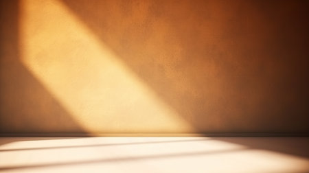 Universal background for presentation in golden brown tones. Textured empty wall with sun highlights and shadowsの写真素材