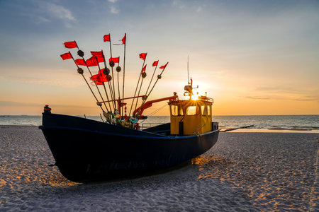Fishing boat on the beach at sunset timeの写真素材