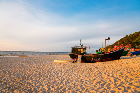 Fishing boats on the beach at sunsetの写真素材