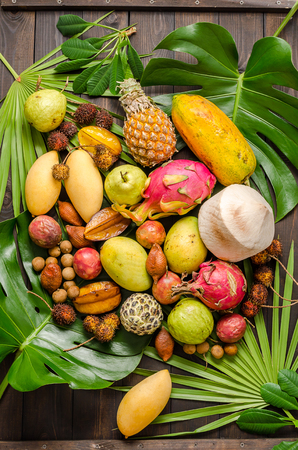 Summer detox with vegan food. Assorted Thai tropical fruits on a dark wooden rustic background.の写真素材