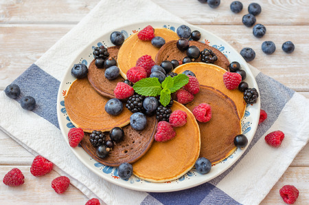 Chocolate and vanilla pancakes in a pan with raspberries, blackberries, blueberries.の写真素材