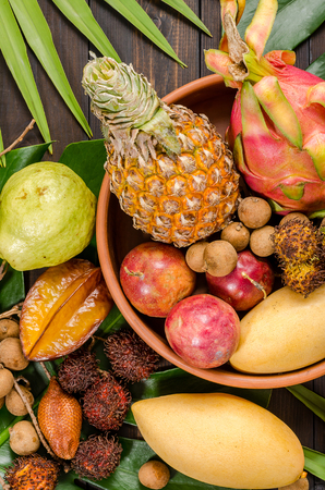 Summer detox with vegan food. Assorted Thai tropical fruits on a dark wooden rustic background.の写真素材