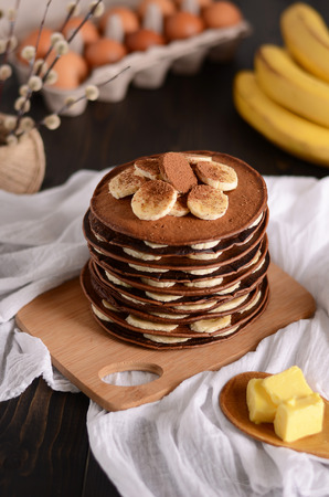 Pancakes with banana,walnut and maple syrup for a breakfast on wooden background closeup.の写真素材