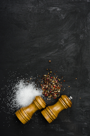 Wooden salt and pepper shaker. Seasoning salt and pepper on black chalk board. Menu cover.の写真素材