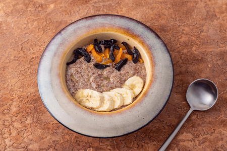 Flax vegan porridge from fresh seeds with almonds and dried apricots on a light background. Source Omega 3.の写真素材