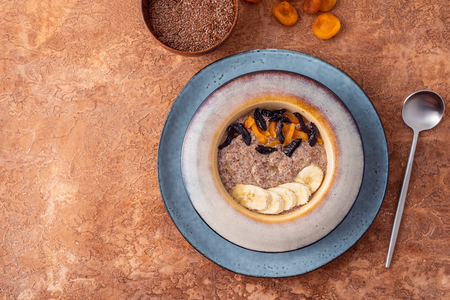Flax vegan porridge from fresh seeds with almonds and dried apricots on a light background. Source Omega 3.の写真素材