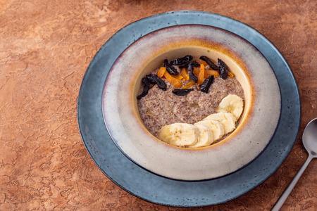 Flax vegan porridge from fresh seeds with almonds and dried apricots on a light background. Source Omega 3.の写真素材
