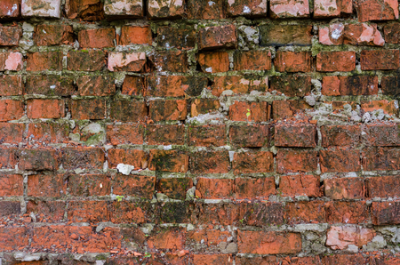 Red brick background. Old, ruined street wall.の写真素材