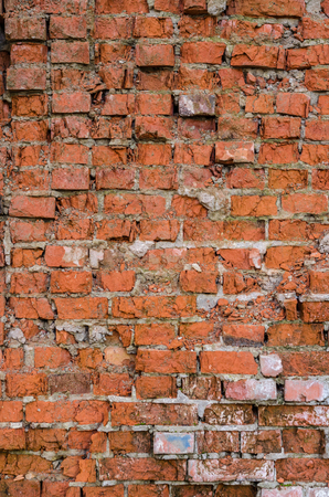 Red brick background. Old, ruined street wall.の写真素材