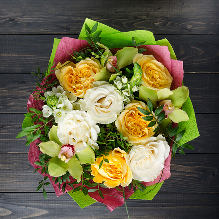 A bouquet of flowers on a dark wooden background. Bouquet with roses.の写真素材
