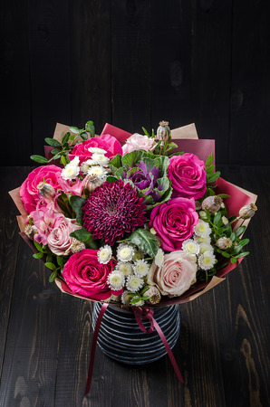 A bouquet of flowers on a dark wooden background. Bouquet with roses.の写真素材