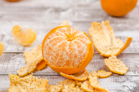 Peele dripe tangerines on wooden light backgroundの写真素材