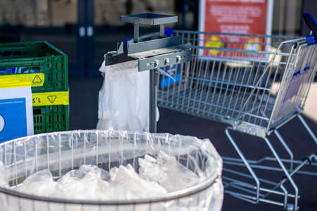 Trash bin full of used disposable wipes and plastic gloves at the entrance of a supermarket to protect customers against coronavirus covid-19 infection. Precautions against the spread of the disease.の写真素材