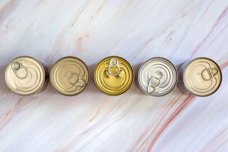 Overhead view row canned food in different sizes and colors. Stock non-perishable preserved food