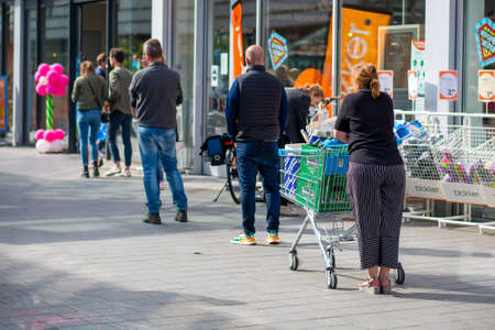 Zwolle, Netherlands - 05 07 2020: Customers queue outside, social distancing. People waiting in line, keeping the necessary social distance, outside of a supermarket due to coronavirus pandemicのeditorial素材
