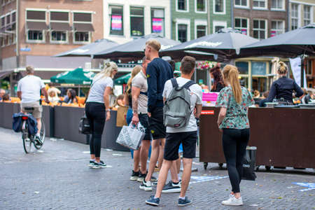 New normal. People wait in line to be allowed on terrace during coronavirus covid-19 pandemic...
