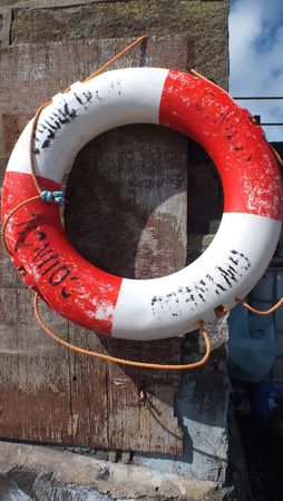 red and white life buoy hanging in a harborの写真素材