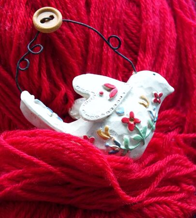 Shabby chic bird decoration in nest of red woolの写真素材