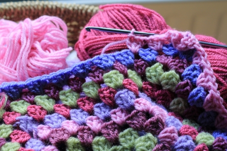 Vintage feel crochet, the making of an afghan blanket, with wool in a basketの写真素材
