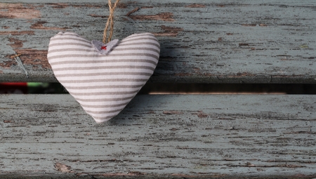A fabric shabby chic hearts on wooden bench, peeling paint