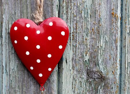 Red spotty heart on a weathered wood, a rustic valentine image の写真素材