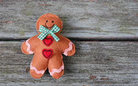 Shabby Chic felt Ginger Bread man on a weathered old wooden bench  の写真素材