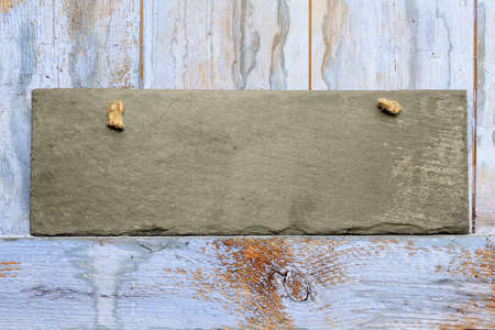 Rectangle blank slate shabby chic sign hanging on a blue weathered a painted shed dooの写真素材