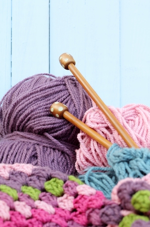 Yarn crafts, wool in purple and pink, crochet afghan blanket, wooden knitting needlesの写真素材