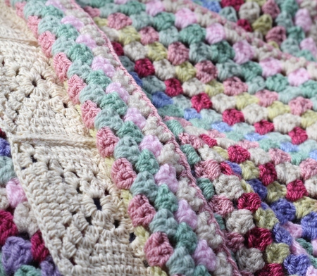A pretty handmade crochet afghan wool blanket , details of different stitch types, vintage shades of creams, pinks, blues and green yarns, a craft and hobbyの写真素材