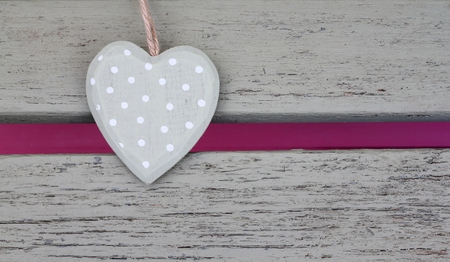 Pale olive spotted shabby chic heart on a painted wooden benchの写真素材